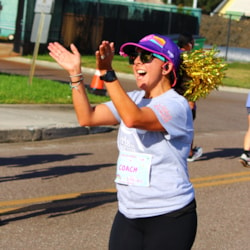 Girls on the run coach holding sign reading intuitive