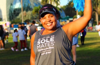 Solemates participant smiles while performing yoga pose outdoors